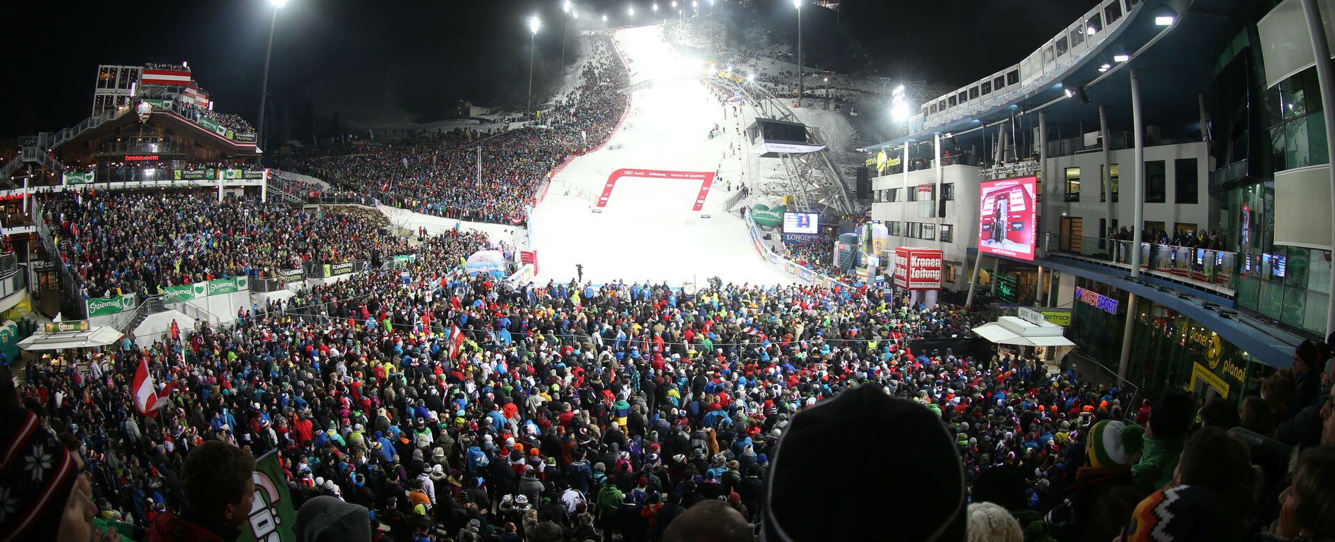 Crowd stands around the finish line of the men's slalom